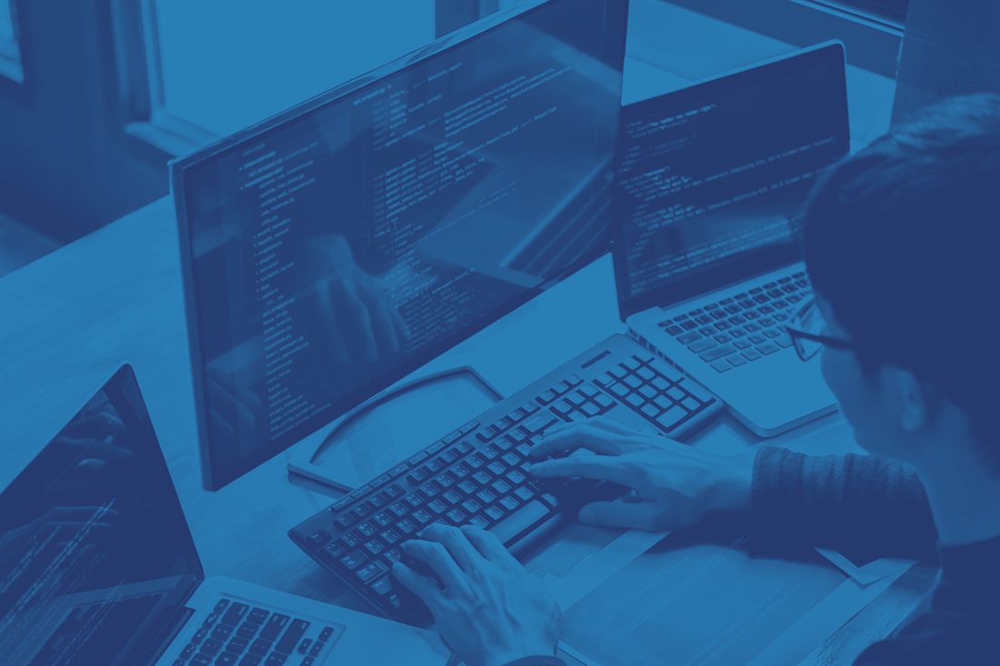 Developer working at a multi-monitor workstation