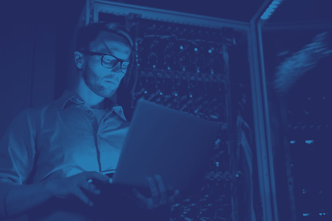Sviluppatore al lavoro su più schermi in un data center Reengineering