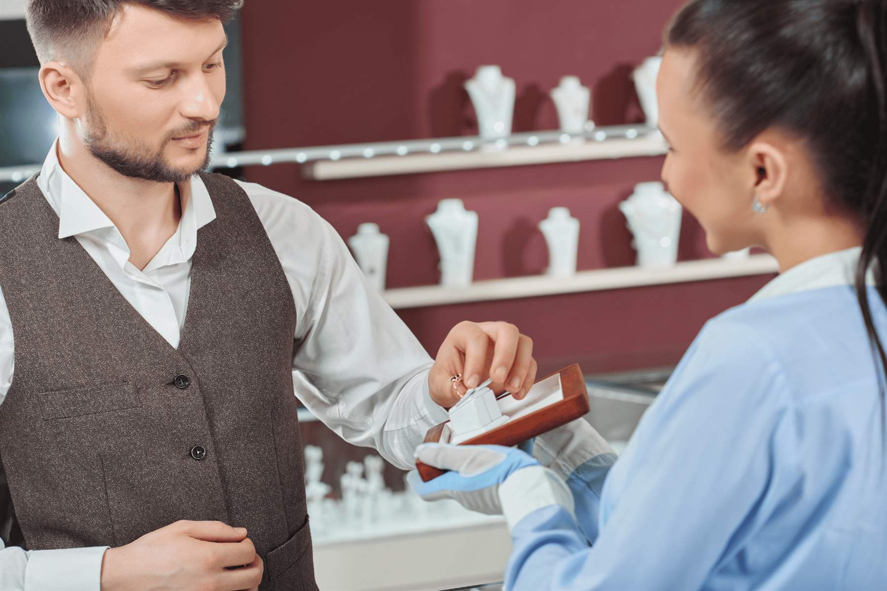 Cliente e commessa con un anello al bancone di una gioielleria